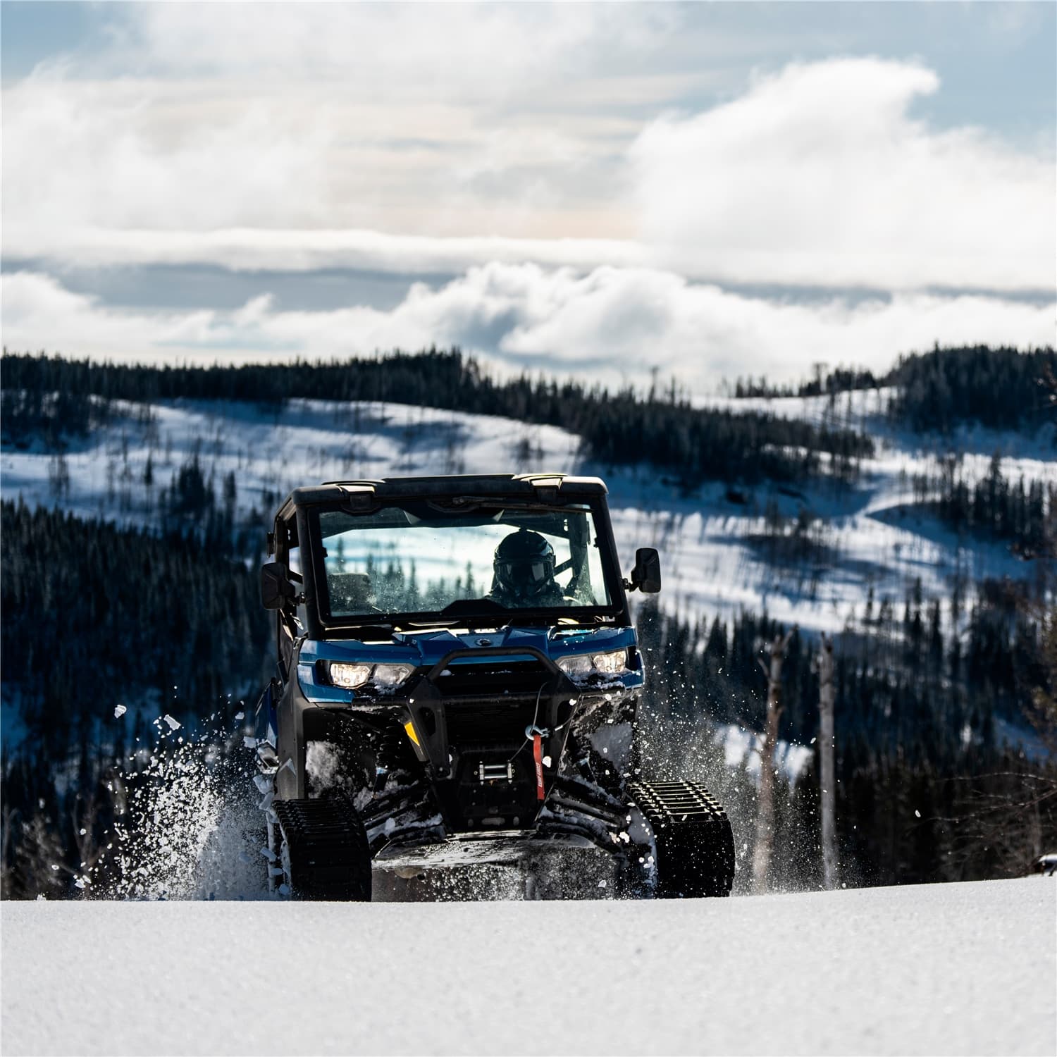 UTV on tracks against a mountain backdrop, real working light