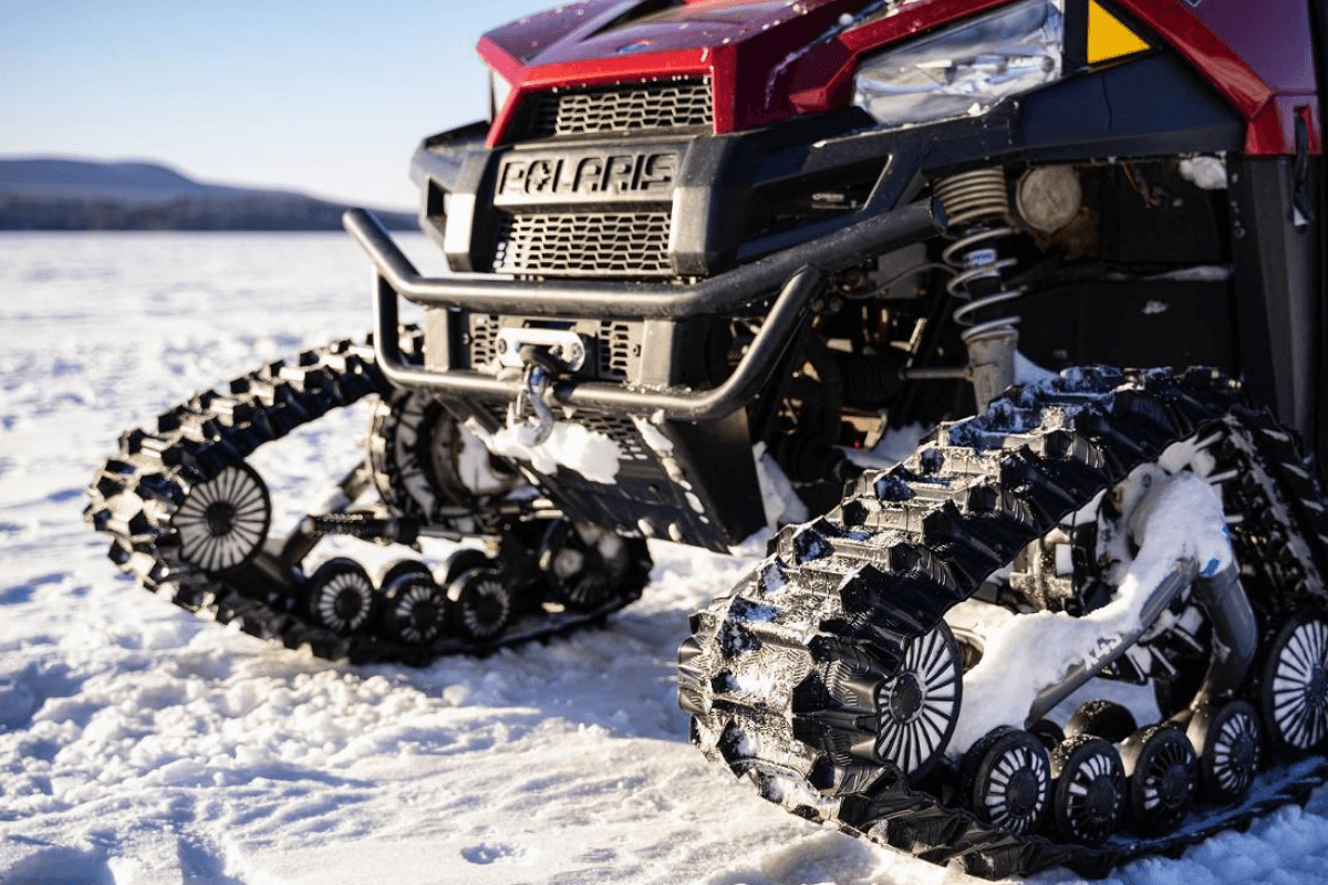 Polaris UTV equipped with Prospector tracks, sitting on a frozen lake