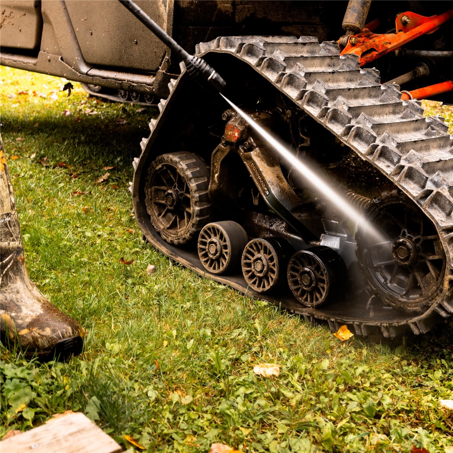 UTV on tracks crossing pasture grass — visible flotation