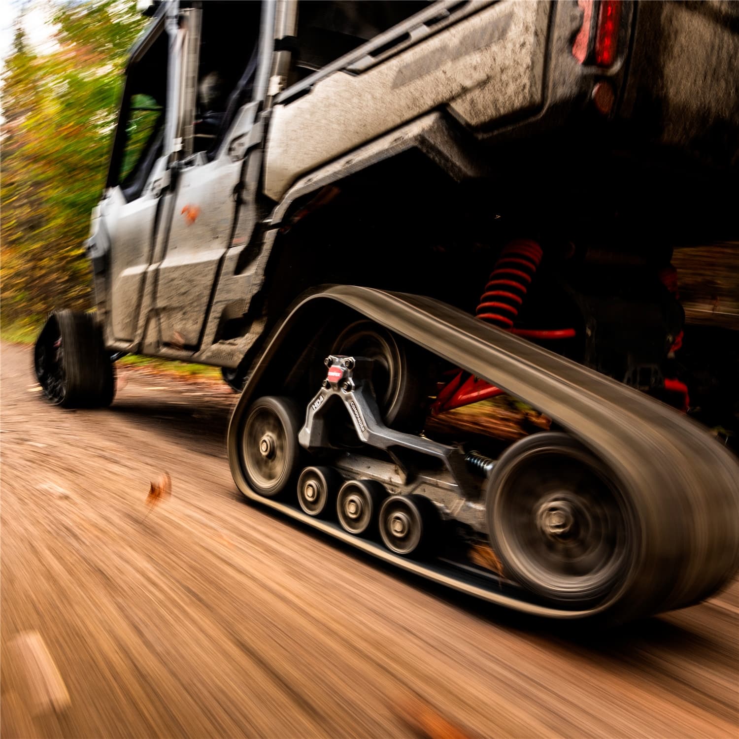UTV on tracks moving down a backcountry dirt road