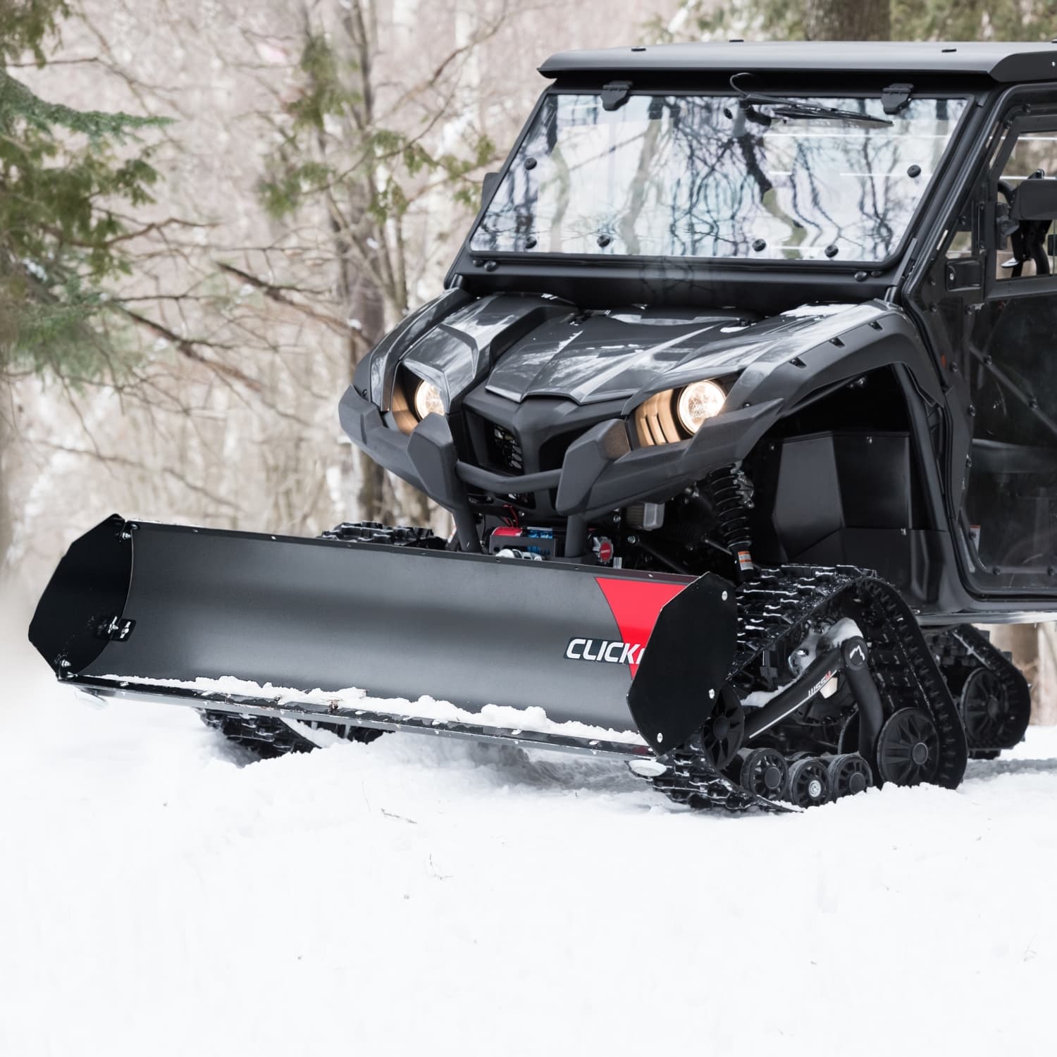 UTV with snow plow attachment pushing through fresh snow